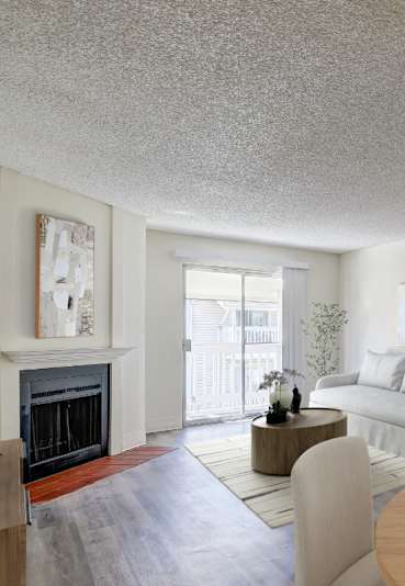 A modern living room with a fireplace and a dining table set for two.