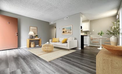 A living room with a white couch and a wooden coffee table.