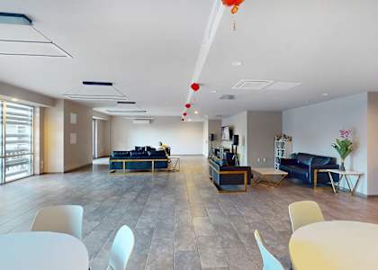 A modern open plan office space with a long table and chairs.