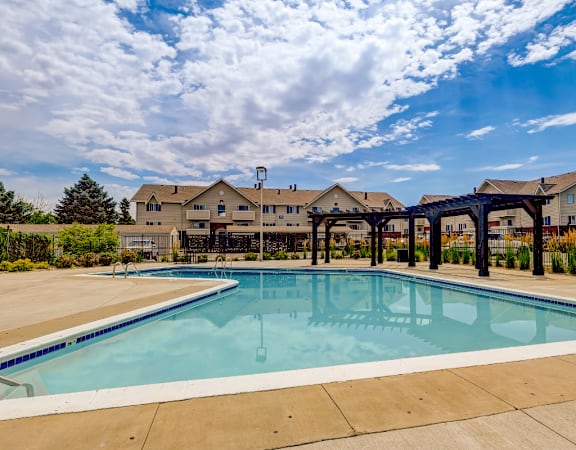 A large outdoor swimming pool with a bridge over it.