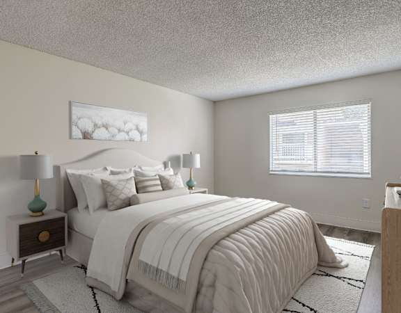 A bedroom with a large bed and a nightstand with a lamp.