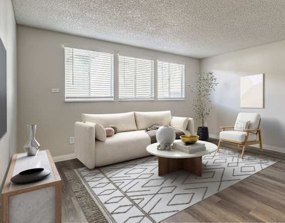 A living room with a white couch, a coffee table, and a chair.