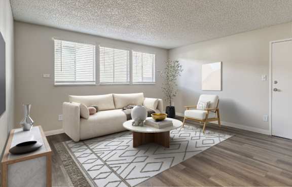 A living room with a white couch, a coffee table, and a chair.