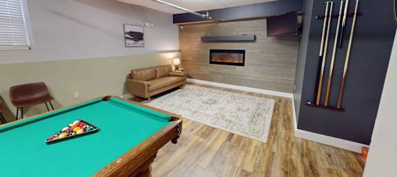 A pool table with a green cloth and a billiard cue.