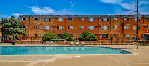 A large swimming pool in front of a brick building.