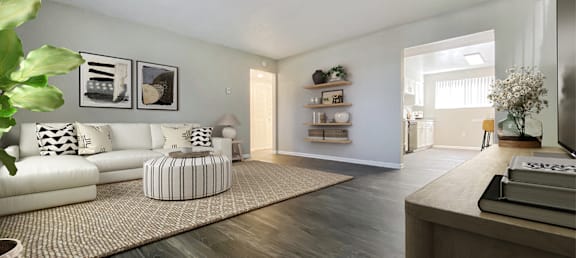 A living room with a white sofa and a wooden floor.