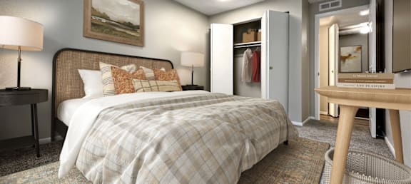 A bedroom with a bed, a desk, and a chair.