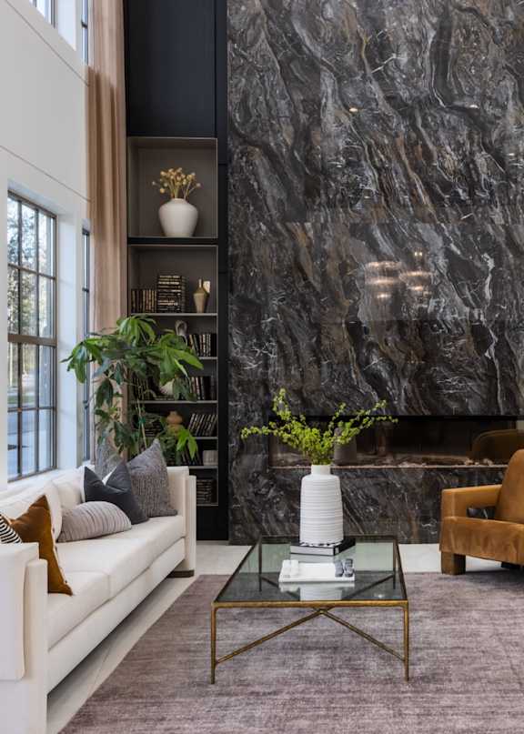 A modern living room with a large abstract painting on the wall and a comfortable seating area.