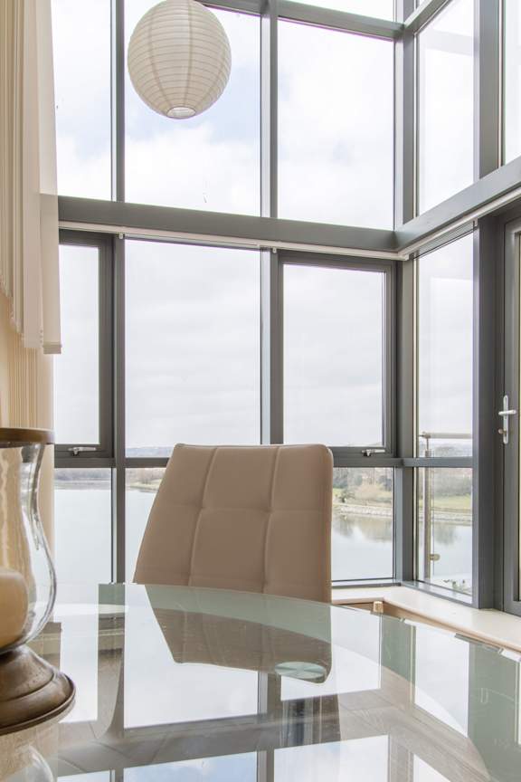 a living room with a glass table and windows