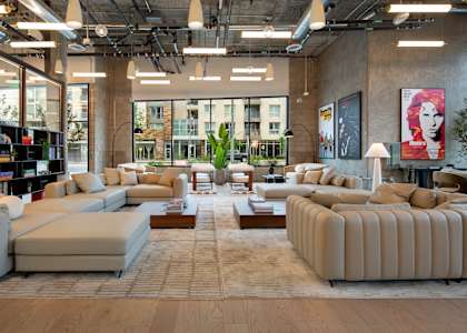 A large, modern living room with a variety of seating options and a view of the city.