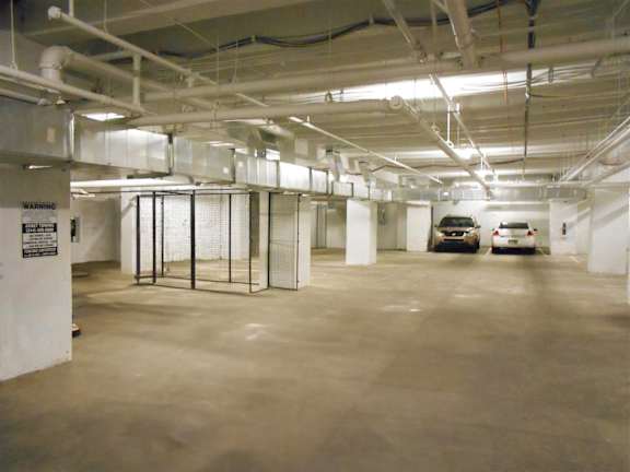A parking garage with a warning sign on the wall.
