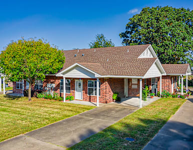 a red brick house with a tree in front of it