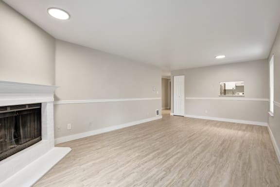an empty living room with a fireplace and wood flooring at 2000 Lake Washington Apartments, Renton, Washington, 98056