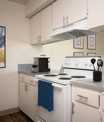 a kitchen with white appliances and white cabinets and a window
