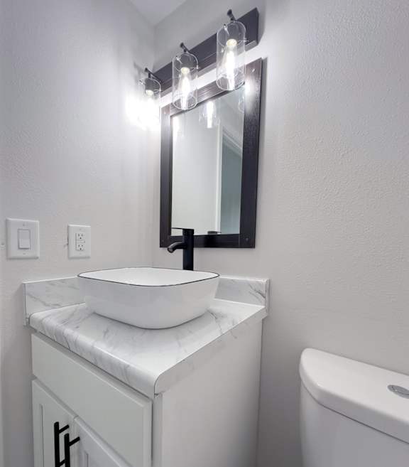 a bathroom with a glass sink and a mirror