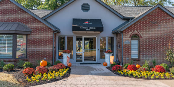 the front entrance of a brick building with pumpkins on the sidewalk at Weaver Farm, Florence, 41042
