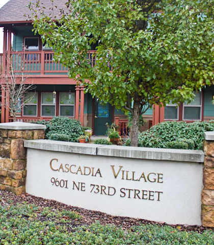 A sign that says Cascadia Village stands in front of a building.