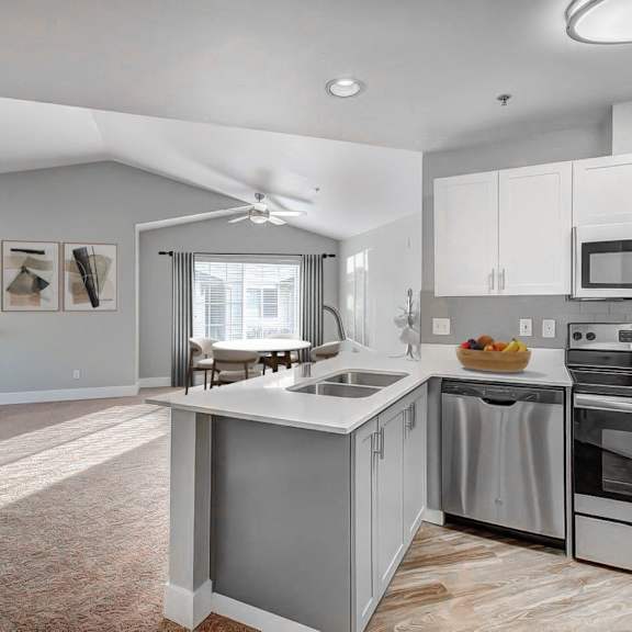 A modern kitchen with stainless steel appliances and white cabinets.