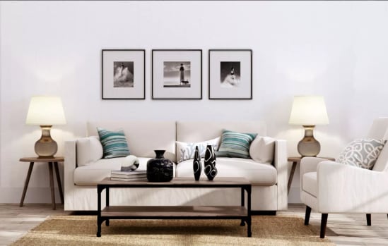 a living room with a white couch and three black and white photos on the wall