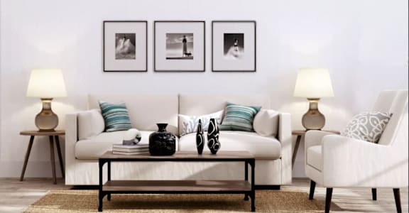 a living room with a white couch and three black and white photos on the wall