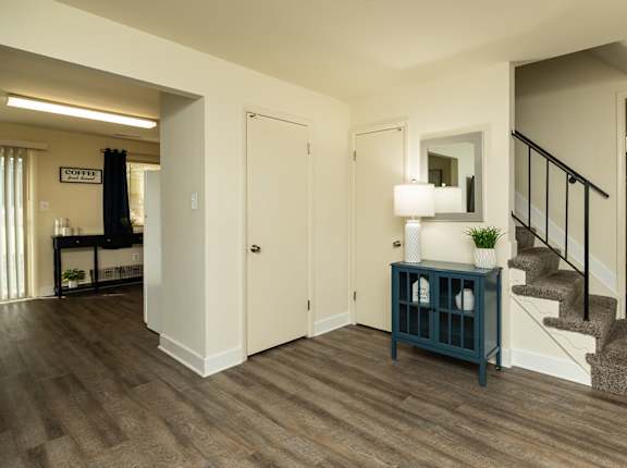A room with a staircase and a cabinet.