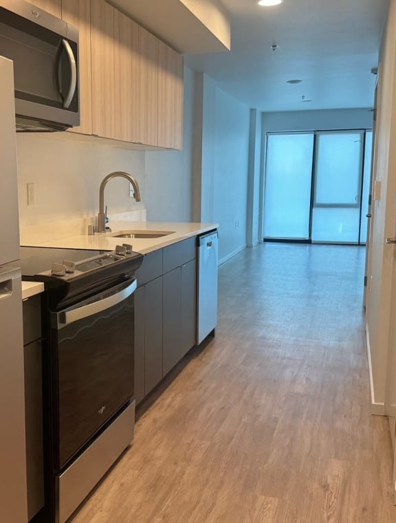 a kitchen with a stove and a refrigerator and a sink at Junction Central, Seattle Washington