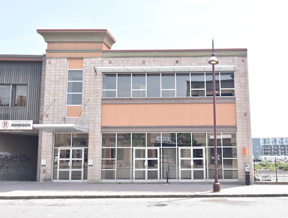 A building with a parking sign on the left side.