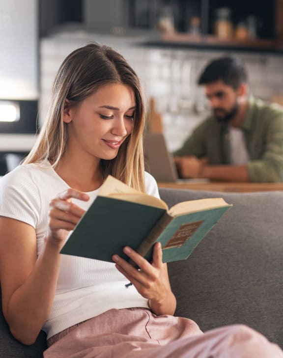 woman sitting on a couch reading a book
