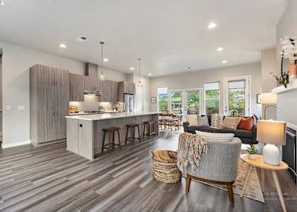 A modern kitchen with a bar area and a living room with a couch.