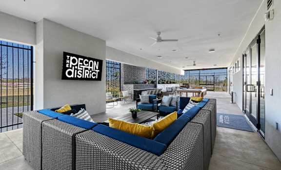 A modern outdoor seating area with a sign that reads "The Peconic District.".