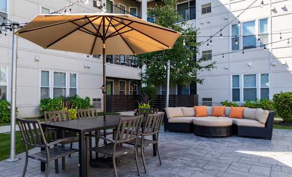 a patio with a table and chairs and an umbrella