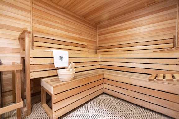 a sauna with a wooden bench and a bucket in it