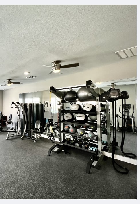 A gym with treadmills, weights, and exercise equipment.