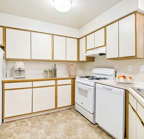 A kitchen with a white gas stove and dishwasher at Canal Club Apartments, Lansing