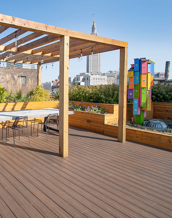 A wooden deck with a table and chairs and a view of a city skyline.