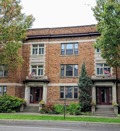 a red brick building with two american flags in front of it
