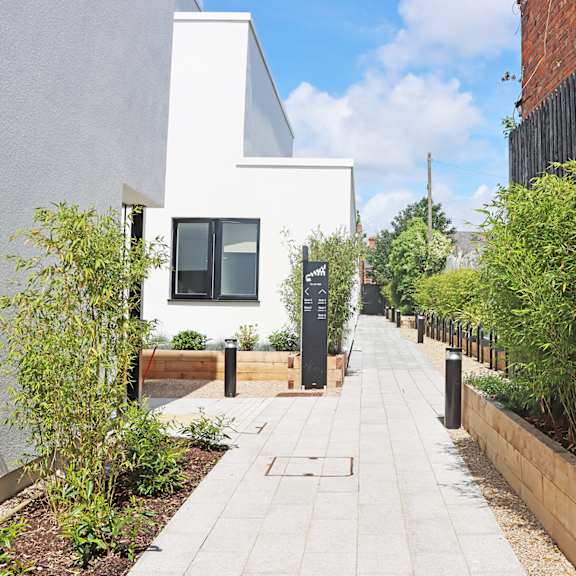 a courtyard with two benches and a table in front of a fence