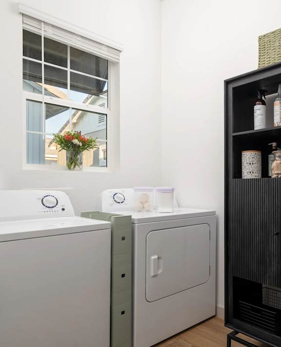 A black shelf with a basket on top and a white cabinet below it.