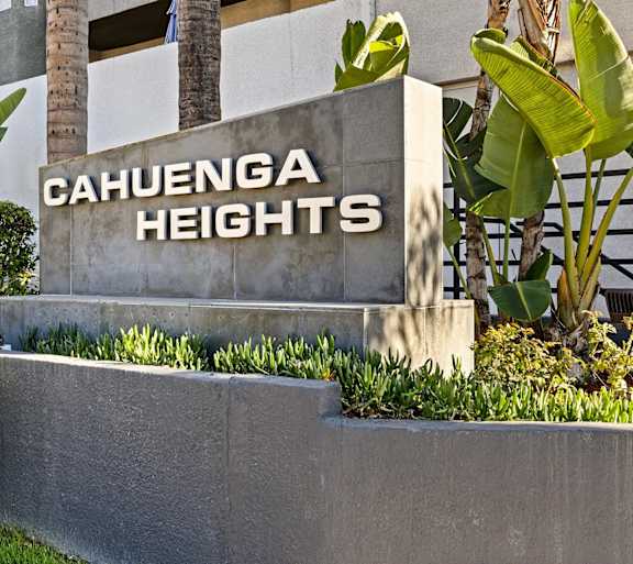 A sign that says Cahuenga Heights in front of some plants.