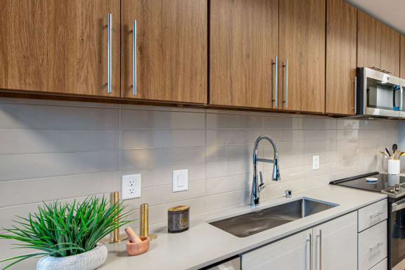 a kitchen with a sink and cabinets and a microwave