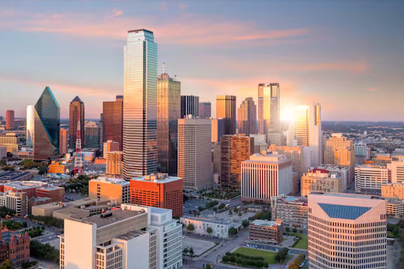 A cityscape with a variety of buildings, including a distinctive tall skyscraper with a curved top.