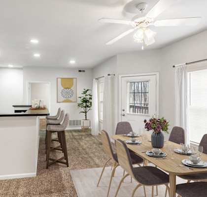 a dining room and kitchen with a table and chairs