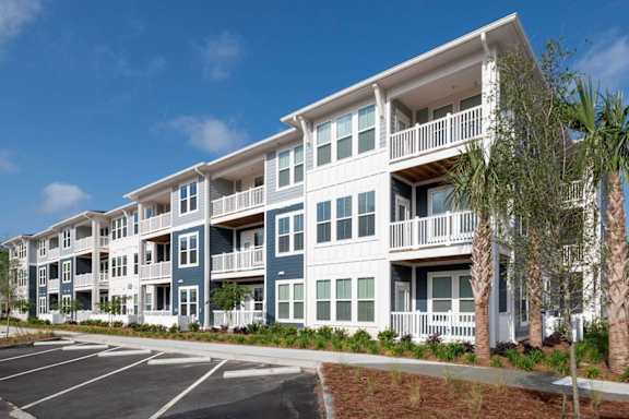 an exterior view of an apartment building with a parking lot at Bristol at New Riverside, Bluffton, SC