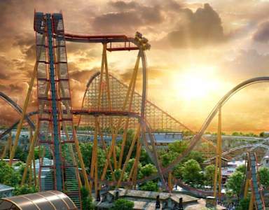 A roller coaster ride in an amusement park during sunset.