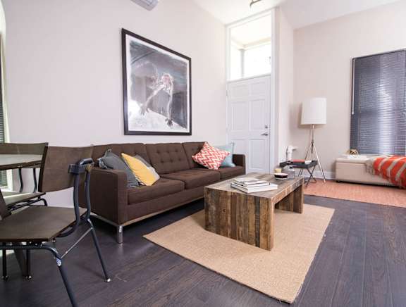 A living room with a brown couch and a coffee table.