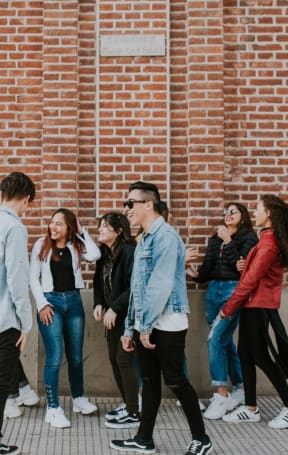 a group of people standing in front of a brick wall