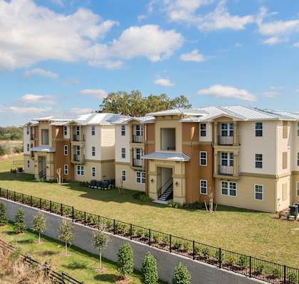 an aerial view of an apartment building with a green lawn