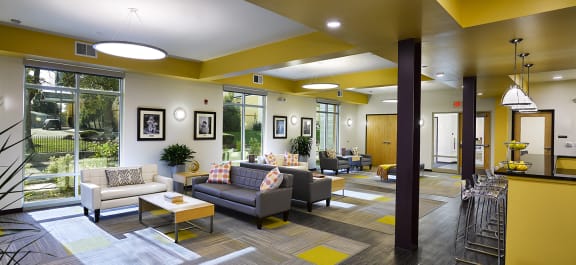 a Clubhouse lobby with a fireplace and a table with chairs with a stone kitchen island
