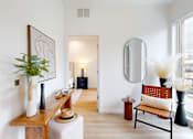 Thumbnail 47 of 51 - A room with a chair and a mirror on the wall.