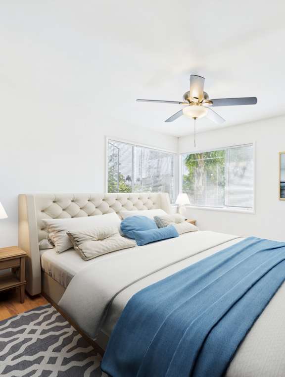 A bedroom with a large bed and a ceiling fan.